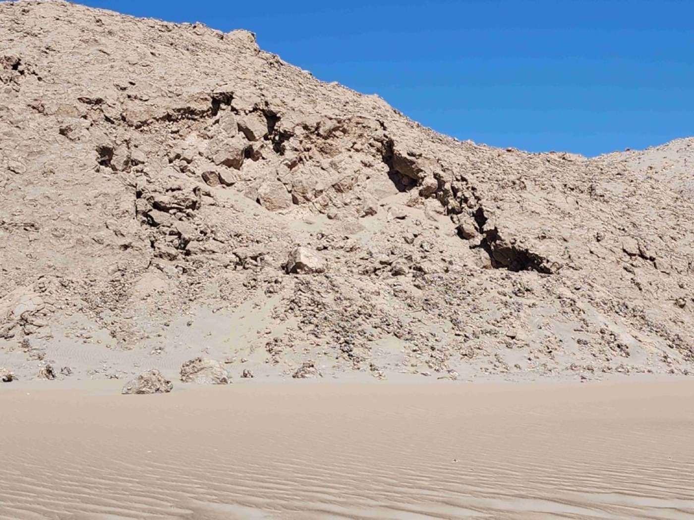 Dunas y faldeo rocoso en entorno desértico