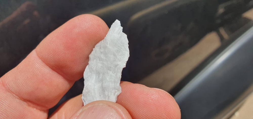 Muestra mineral sostenida en terreno